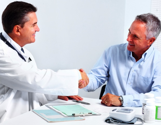 Smiling medical doctor with senior man. Health care.